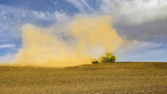 Tractor Plowing Dusty Field