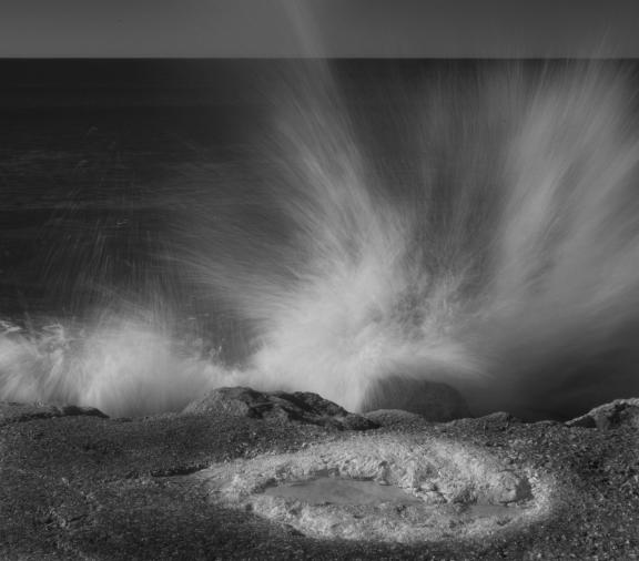 A wave crashes against the rocks